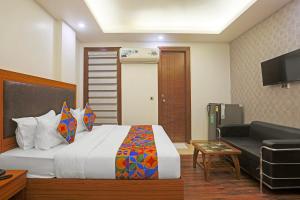 a hotel room with a bed and a couch at FabHotel Star Inn - Near Apollo Hospital in New Delhi