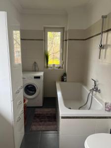 ein Badezimmer mit Badewanne und Waschmaschine in der Unterkunft Comfy & Cozy Apartment in Neuenhagen + 10 Fotos