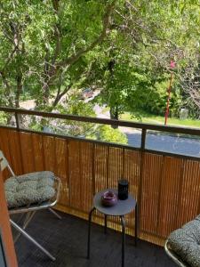 einen Balkon mit einem Tisch, einem Stuhl und einem Fenster in der Unterkunft Comfy & Cozy Apartment in Neuenhagen