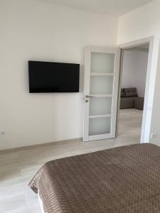 a bedroom with a bed and a tv on a wall at ATLANT luxury Big Family Five Apart - ТЦ ДЕПОТ in Chernivtsi