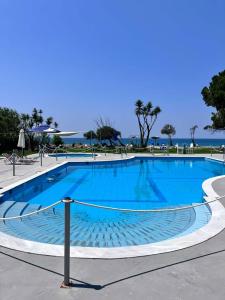 ein großer blauer Swimmingpool direkt am Meer in der Unterkunft Nostos Mare in Preveza