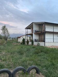 a house on top of a hill with a fence at Eco Village Lodge in Dzhetyoguz