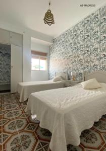 a bedroom with two beds and a wall mural at Casa Bienvenida in Bienvenida