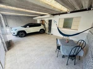 ein in einer Garage geparktes Auto mit einem Tisch in der Unterkunft Casa de 2 Quartos à 5 min a Pé da Praia, com Churrasqueira e 3 Vagas de Garagem in Praia Grande