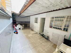 ein leeres Zimmer mit einem Tisch und Stühlen in einem Gebäude in der Unterkunft Casa de 2 Quartos à 5 min a Pé da Praia, com Churrasqueira e 3 Vagas de Garagem in Praia Grande + 35 Fotos