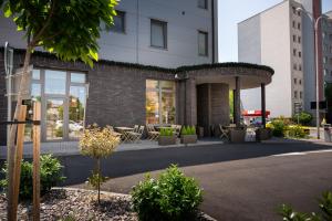 a building with a patio with tables and chairs at Emerald Residence Apartments in Dunajská Streda