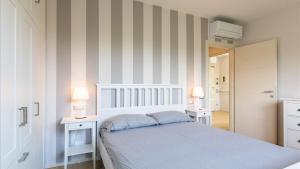 a bedroom with a bed and two tables and two lamps at Luxury Apartments in Modern Villa in Imperia