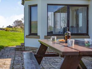 un tavolo da picnic in legno di fronte a una casa di 3 Bed in Berwick-upon-Tweed 87777 a Lamberton