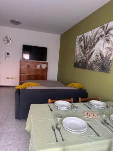 a room with a bed and a table with plates on it at Relax stefy apartment in Zelarino +8 photos