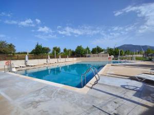 a large swimming pool with lounge chairs in a resort at Duplex GABY in Sabiñánigo
