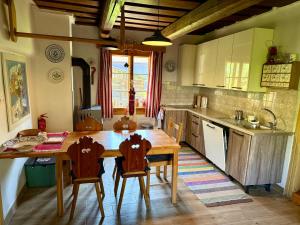 a kitchen with a wooden table and four chairs at Drevenica Linda in Liptovská Osada