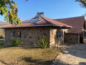 una casa in pietra con tetto rosso di Nyanga Home in Private Village 2033 a Nyanga