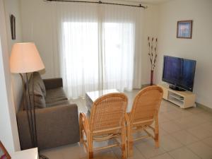 Una sala de estar con un sofá y sillas y un televisor. en Estartit Park 3-2, en Torroella de Montgrí