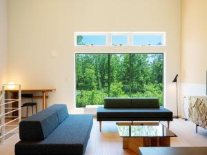 a living room with two couches and a large window at Minn house Niseko Hirafu in Kutchan