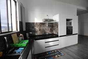 a kitchen with white cabinets and a black counter top at Elizabeths Home Away From Home in Nadi