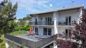 a large white house with a deck and patio at Villa Mira in Klopein am Klopeiner See