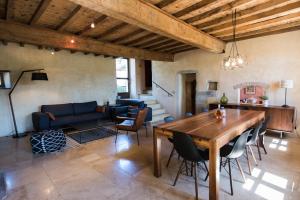 a living room with a wooden table and chairs at Les Nuits du Taris in Bourdeaux