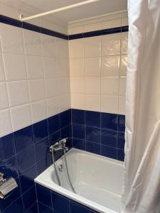 a bathroom with a tub with blue and white tiles at Teresa's sweet home in Cudillero +23 photos