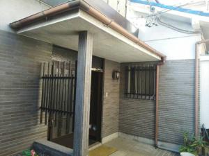 uma porta da frente de um edifício com um portão de ferro em Guesthouse Face to Face em Fujinomiya