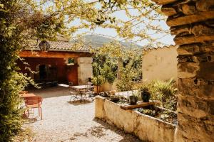 an outdoor patio with chairs and tables and a building at Les Nuits du Taris in Bourdeaux