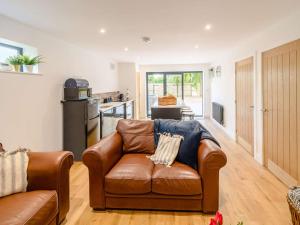 a living room with a leather couch and a kitchen at 2 Bed in Hedon 89596 in Ryhill +14 photos