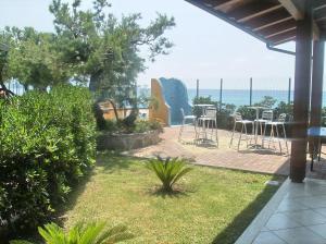 eine Terrasse mit Stühlen und Meerblick im Hintergrund in der Unterkunft Hotel Residence Riviera Calabra in Zambrone