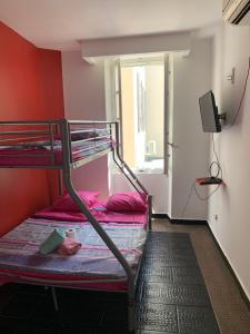 a room with two bunk beds and a television at Hôtel Le Capitol in Marseille
