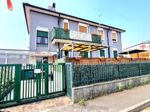 a green fence in front of a building at Italo House in Opera