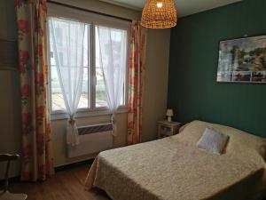 a bedroom with a bed and a large window at La Villa in La Tranche-sur-Mer