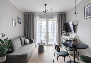 a living room with a couch and a table at Baltic Sands Apartment- 15 min Beach Free Parking Premium Letnica in Gdańsk