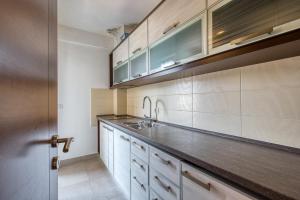 a kitchen with a sink and wooden cabinets at Studio apartment in the centre of Budva in Budva