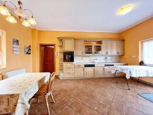 a large kitchen with wooden cabinets and a table at Pokoje u Marka in Niekanin