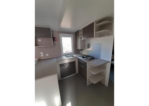 O bucătărie sau chicinetă la Mobil-home Clim, TV, LV, LL Camping LA CARABASSE 4étoiles - MH-A014
