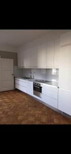 a kitchen with white cabinets and a stove top oven at Fria Bad in Helsingborg