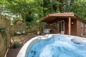 una bañera de hidromasaje en un patio trasero con una casa en The Hideaway, en Bath