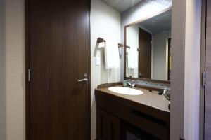a bathroom with a sink and a large mirror at Onyado Nono Matsumoto Natural Hot Spring in Matsumoto
