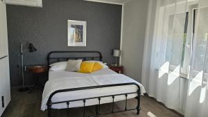 a bedroom with a bed with yellow pillows and a window at Apartments 4U in Omišalj