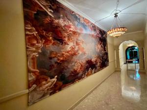un grande dipinto appeso a un muro in un corridoio di Triple room in Beautiful Artsy Maisonette a San Giuliano Altre 2 foto