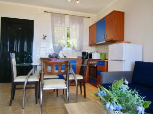 a kitchen with a table and chairs and a refrigerator at Barbati Beach Apartments in Barbati