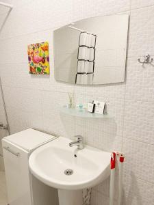 ein weißes Badezimmer mit Waschbecken und Spiegel in der Unterkunft Studio Green Rublyovka in Warna