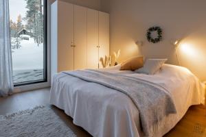 Un dormitorio con una cama y una ventana grande en Villa Suunnikas by Hilla Villas, en Ylläsjärvi