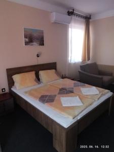 a large bed in a room with a couch at Start Panzió-Étterem in Hajdúszoboszló