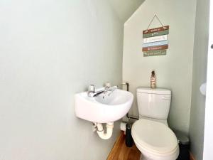 a bathroom with a white toilet and a sink at Fijnbosch Villa at Claptons in Jeffreys Bay +5 photos
