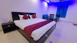 ein Schlafzimmer mit einem großen Bett mit roten Kissen in der Unterkunft Valley Springs Resorts in Araku