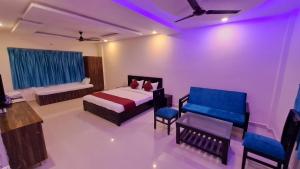 ein Schlafzimmer mit einem Bett, einer Couch und Stühlen in der Unterkunft Valley Springs Resorts in Araku