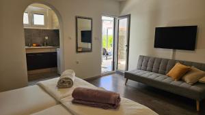 a living room with a couch and a tv at Apartments 4U in Omišalj