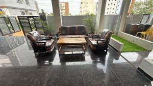 two chairs and a coffee table on a balcony at COCO NET Hotel in Ibrāhīmpatan