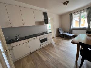 a kitchen with white cabinets and a sink and a table at Wohnung Albrecht Nummer 4 in Spalt +2 photos