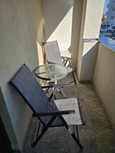 two chairs and a glass table on a balcony at Ana Residence in Timişoara