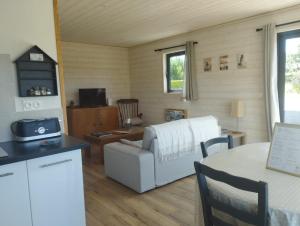 a living room with a white couch and a table at Chalet - Cottage de Lesconil in Plobannalec-Lesconil